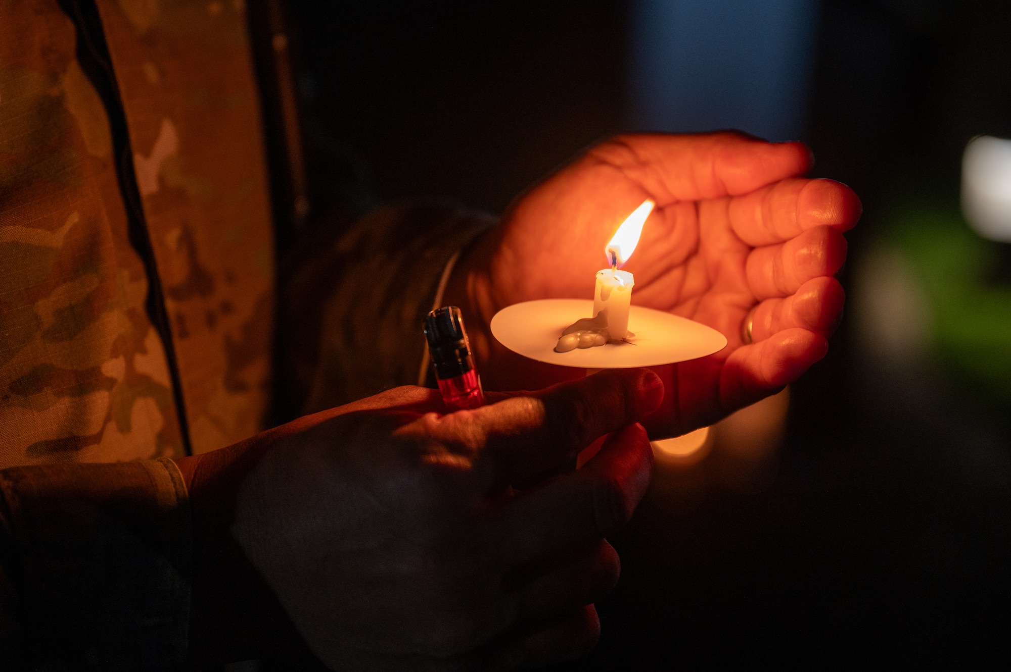 Airman holds a burning candle. (U.S. Air Force photo by Airman 1st Class Skylar Ellis)