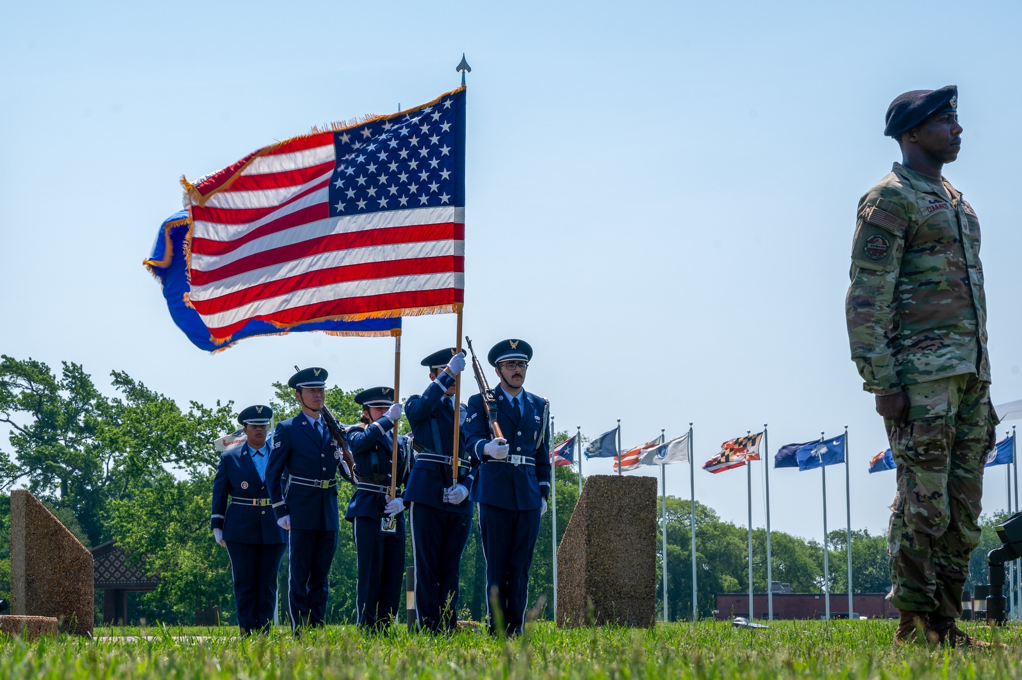 Airmen hold flags while standing at attention. (U.S. Air Force photo by Senior Airman Ian Sullens)