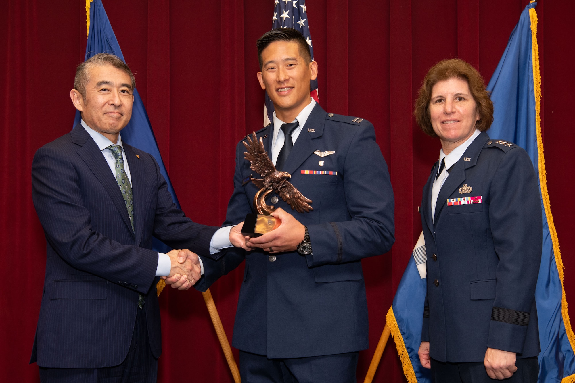 photo of Edwin Oshiba, Performing the Duties of Under Secretary of the Air Force, and Air University Commander and President Lt. Gen. Andrea Tullos present the 2025 Secretary of the Air Force Leadership award in the Company Grade Officer student category to Captain Christian A. Bergman at Maxwell Air Force Base, Alabama, May 6, 2025.