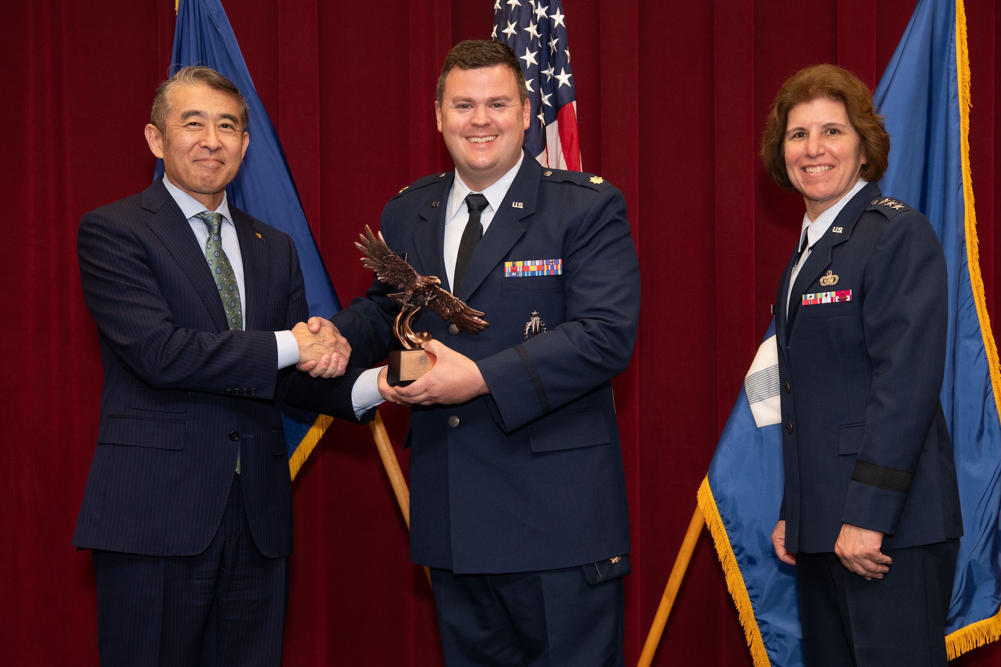 photo of Edwin Oshiba, Performing the Duties of Under Secretary of the Air Force, and Air University Commander and President Lt. Gen. Andrea Tullos present the 2025 Secretary of the Air Force Leadership award in the Field Grade Officer faculty category to Major Adam T. Carswell at Maxwell Air Force Base, Alabama, May 6, 2025