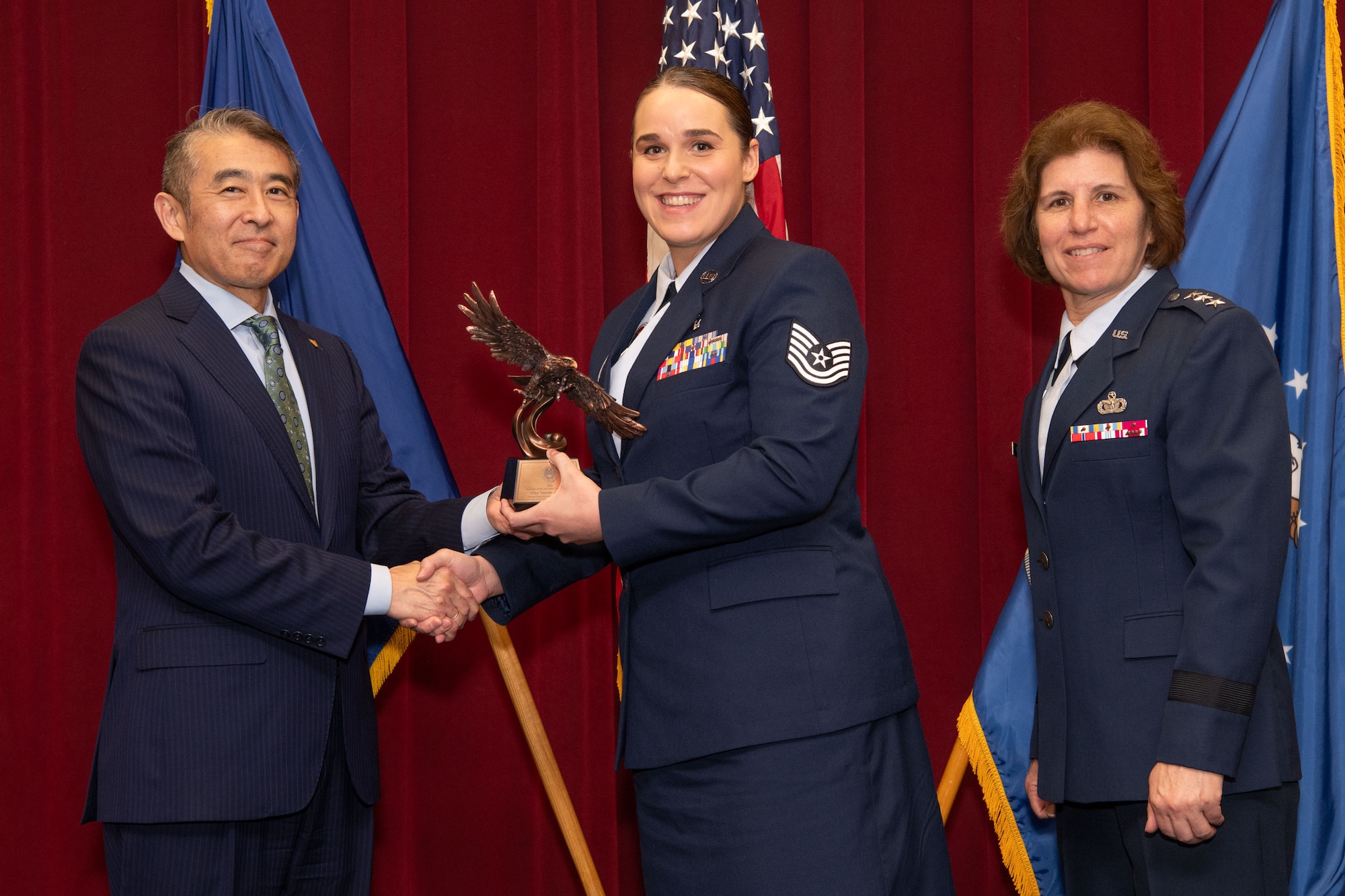 Photo of Edwin Oshiba, Performing the Duties of Under Secretary of the Air Force, and Air University Commander and President Lt. Gen. Andrea Tullos present the 2025 Secretary of the Air Force Leadership award to Technical Sergeant Taylor Koebel at Maxwell Air Force Base, Alabama, May 6, 2025. Koebel distinguished herself as the Operations NCOIC at the Mathies NCO Academy, Keesler Air Force Base, Mississippi.