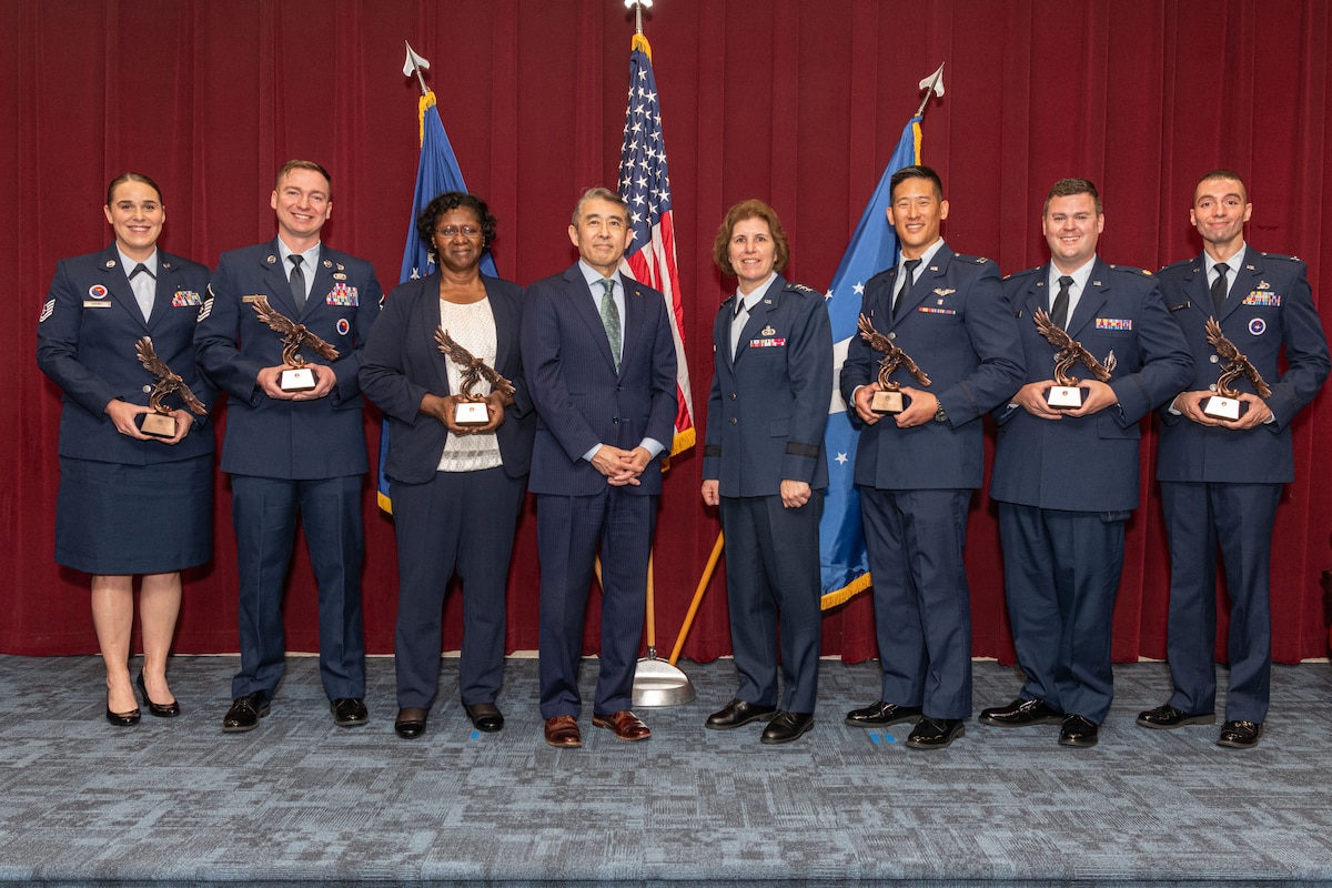 group photo of Edwin Oshiba, Performing the Duties of Under Secretary of the Air Force, and Air University Commander and President Lt. Gen. Andrea Tullos congratulate Technical Sergeant Taylor Koebel, Master Sergeant Jacob M. Stubblefield, Dr. Evelyn Watkins-Bean, Captain Christian A. Bergman, Major Adam T. Carswell and Captain Esah Bouziane upon receiving The Secretary of the Air Force Leadership Award at Maxwell Air Force Base, Alabama, May 6, 2025.