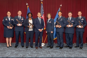 group photo of Edwin Oshiba, Performing the Duties of Under Secretary of the Air Force, and Air University Commander and President Lt. Gen. Andrea Tullos congratulate Technical Sergeant Taylor Koebel, Master Sergeant Jacob M. Stubblefield, Dr. Evelyn Watkins-Bean, Captain Christian A. Bergman, Major Adam T. Carswell and Captain Esah Bouziane upon receiving The Secretary of the Air Force Leadership Award at Maxwell Air Force Base, Alabama, May 6, 2025.
