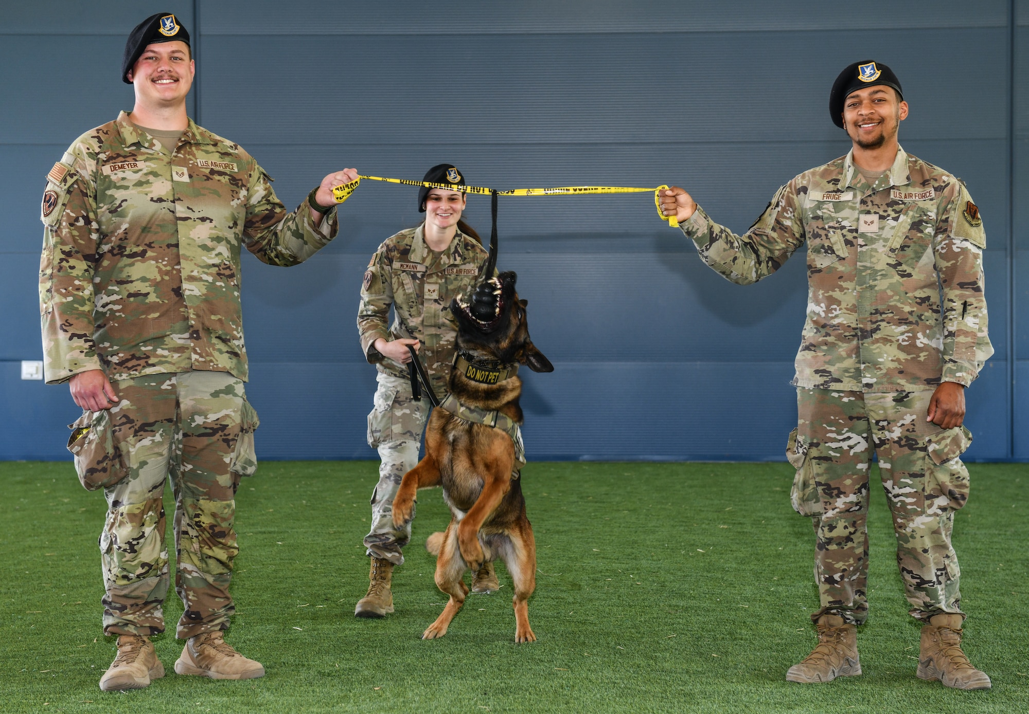 Senior Airman Kari McMann, 55th Security Forces Squadron military working dog handler, releases Maks, 55th SFS MWD, to bite the ribbon held by Staff Sgt. Trey Demeyer, 55th SFS MWD handler, and Senior Airman Ryan Fruge, 55th SFS MWD handler, during the opening of the new military working dog facility on Offutt Air Force Base, May 12. (U.S. Air Force photo by Chad Watkins)