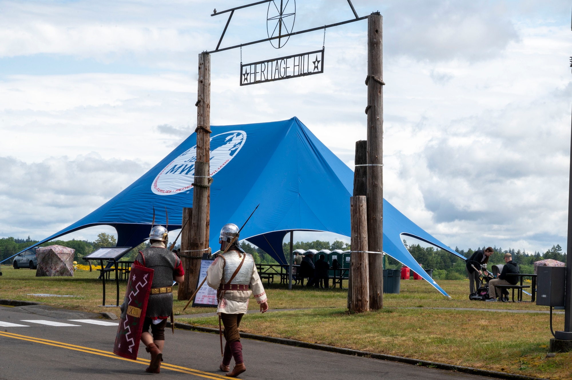 Historical reenactors in period attire walk in front of the Heritage Hill sign during Armed Forces Day at Joint Base Lewis-McChord, Washington, May 17, 2025.