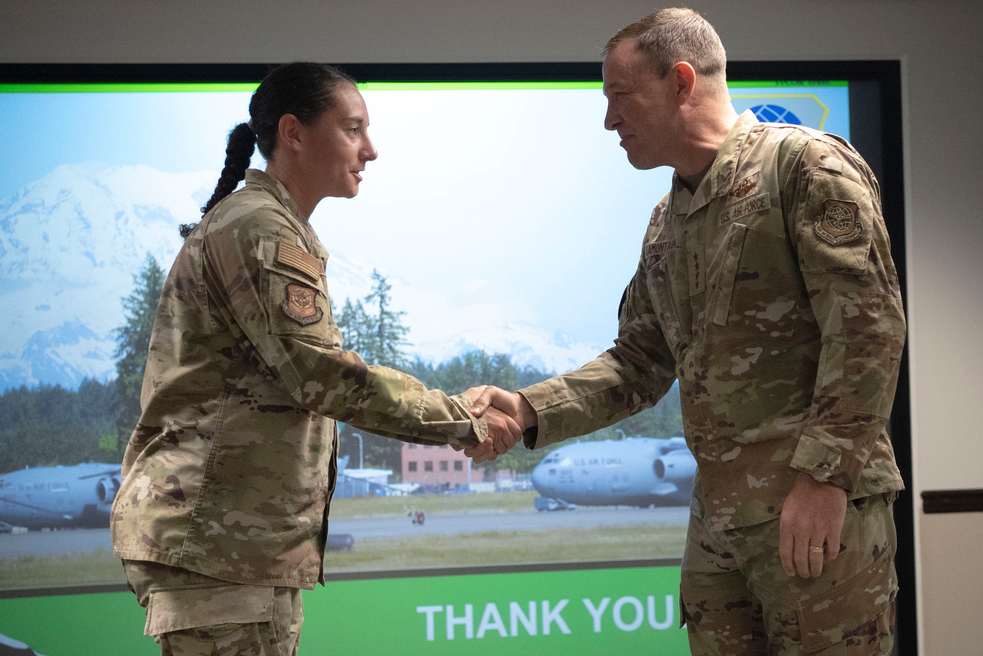 U.S. Air Force Gen. John Lamontagne, Air Mobility Command commander, coins Capt. Alexandria Kahalley, 62d Airlift Wing commander’s action group chief, at Joint Base Lewis-McChord, Washington, May 19, 2025.