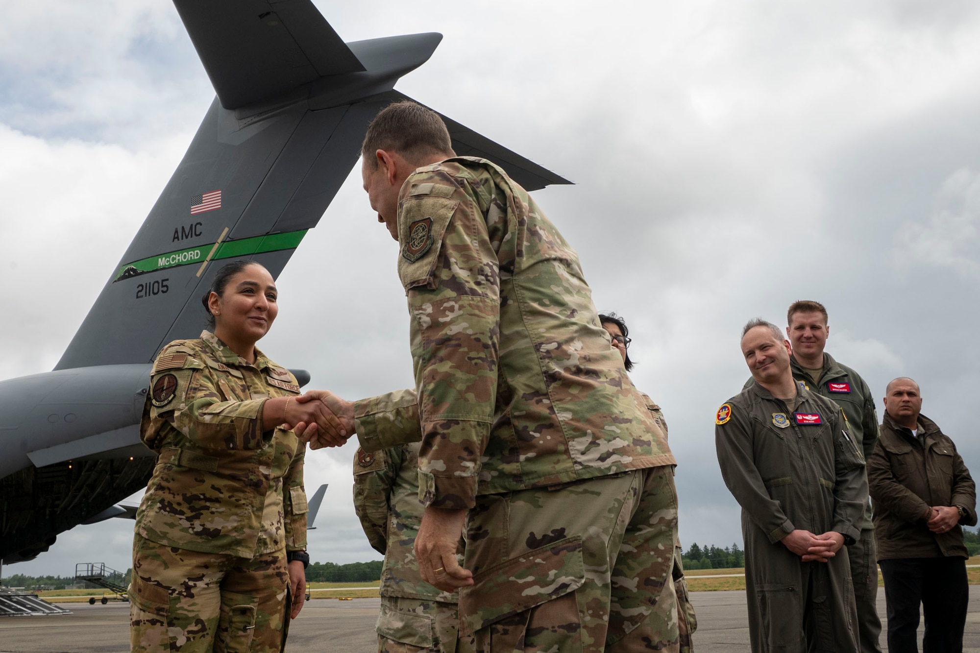 U.S. Air Force Gen. John Lamontagne, Air Mobility Command commander, coins Senior Airman Asmaa Awad, 7th Airlift Squadron loadmaster, at Joint Base Lewis-McChord, Washington, May 19, 2025.