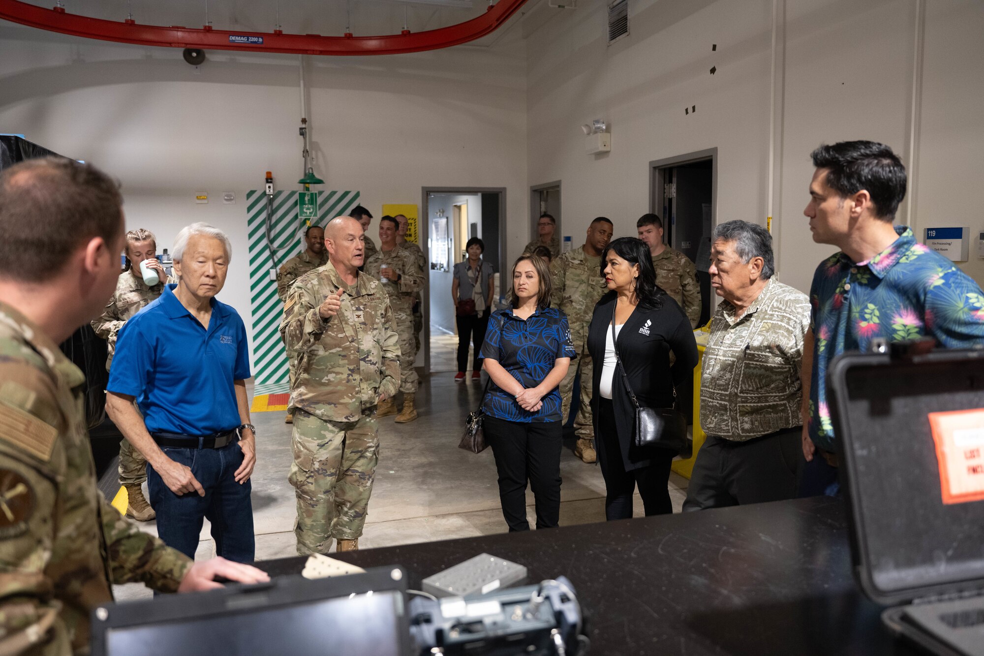 A U.S. Air Force Airmen explains the importance of the non-destructive inspection shop to civilians.