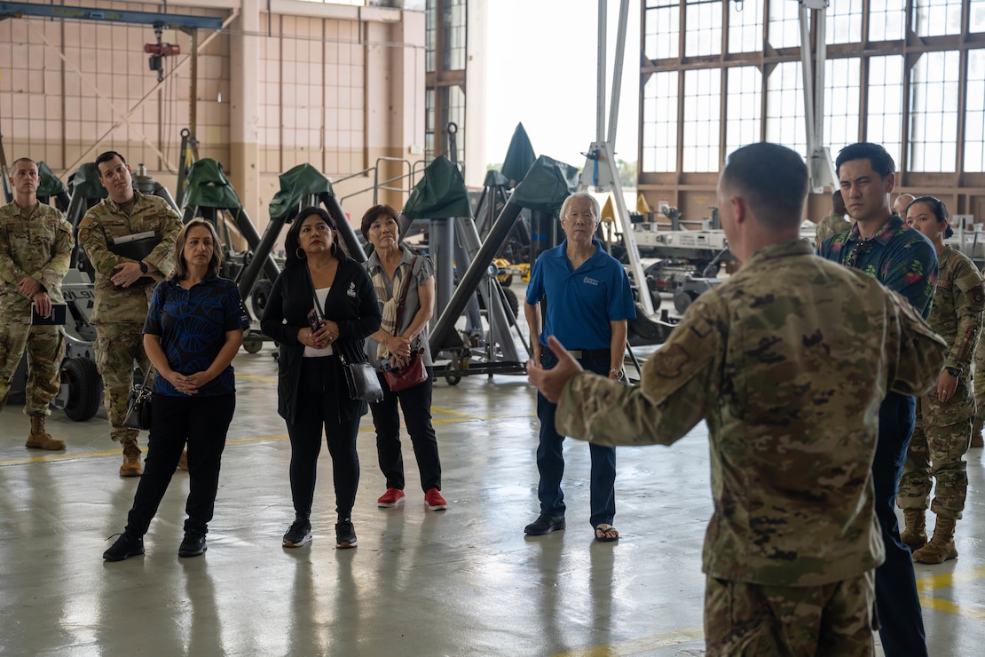 A U.S. Air Force Airmen talks to civilians in a hangar on Joint Base Pearl Harbor-Hickam, Hawaii.