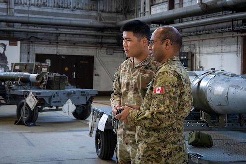 One U.S. Air Force member talks to a member of the Canadian military.
