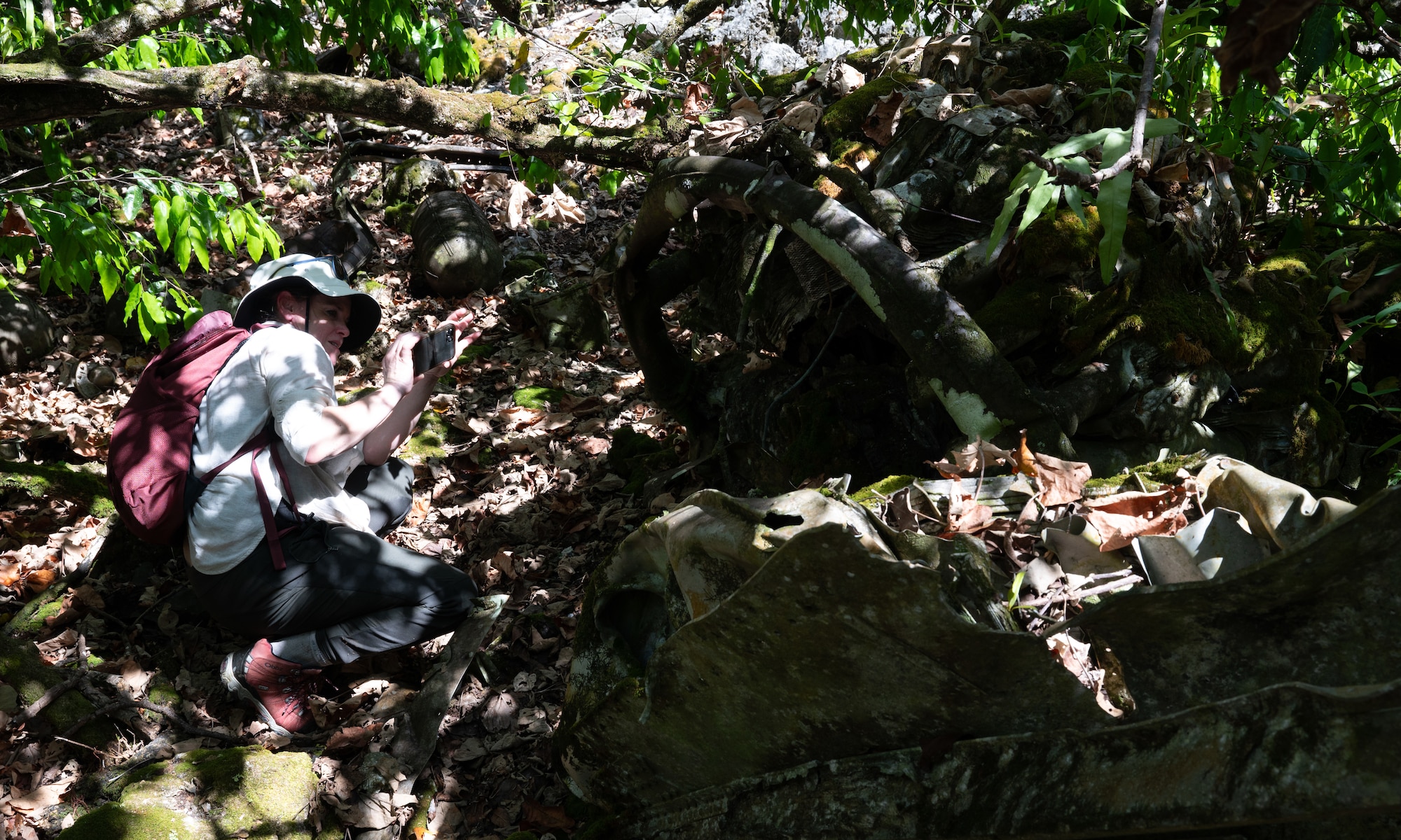 Caitlin Pianetta, great niece of Capt. Carl Bauer, takes photos of debris at the B-29 "Colleen" crash site on Andersen Air Force Base, Guam, April 11, 2025. Caitlin is the historian in her family and joined her mother, Liz Pianetta, to see their own family's history in Guam. This crash site would be where Capt. Carl Bauer, Caitlin's great uncle, perished in a tragedy involving engine troubles and bad weather. Caitlin and her family came to pay their respects to their family member on the 80th anniversary of the accident. (U.S. Air Force photo by Staff Sgt. Pedro Tenorio)