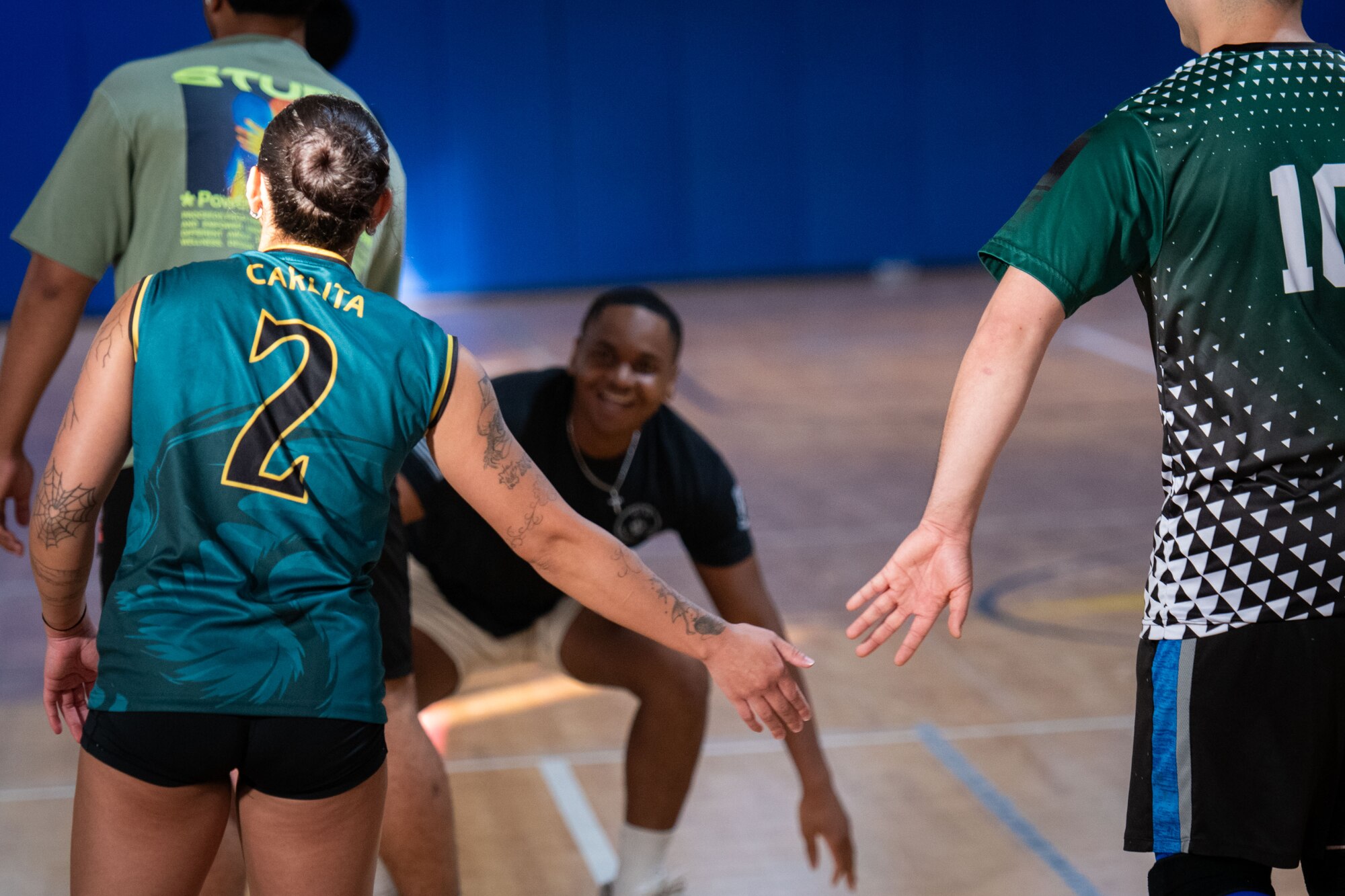 U.S. Airmen gives a low five during a volleyball within the U.S. Central Command area of responsibility, May 16, 2025. Volleyball was one of several events held during the 379th Air Expeditionary Wing Sports Day celebration, in addition to kickball, pickleball and dodgeball games. (U.S. Air Force Photo by Staff Sgt. Sean Moriarty)