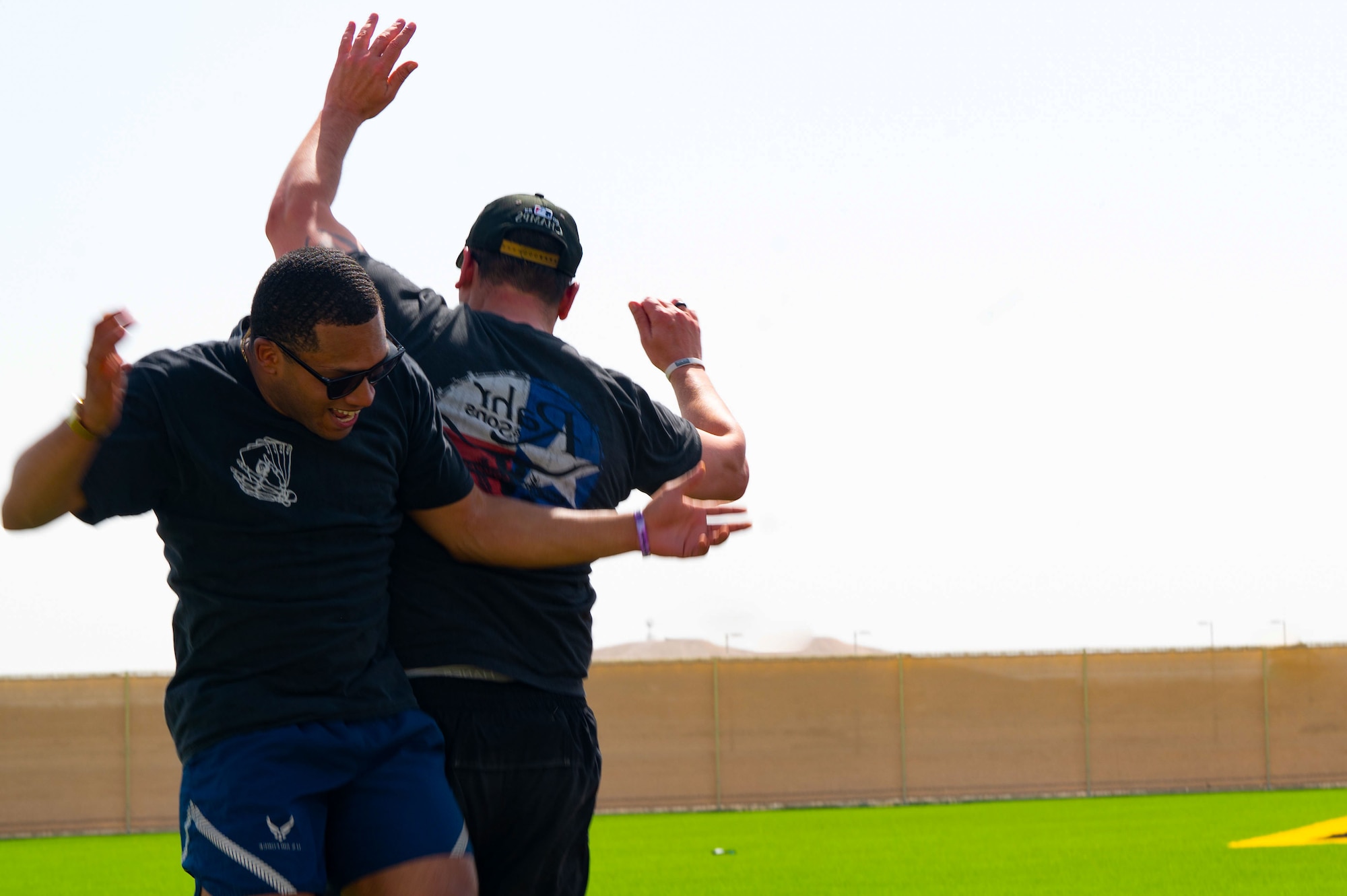 U.S. Airmen celebrate a score during a kickball game within the U.S. Central Command area of responsibility, May 16, 2025. Kickball was one of several events held during the 379th Air Expeditionary Wing Sports Day celebration, in addition to volleyball, pickleball and dodgeball games. (U.S. Air Force Photo by Senior Airman Dieondiere Jefferies)