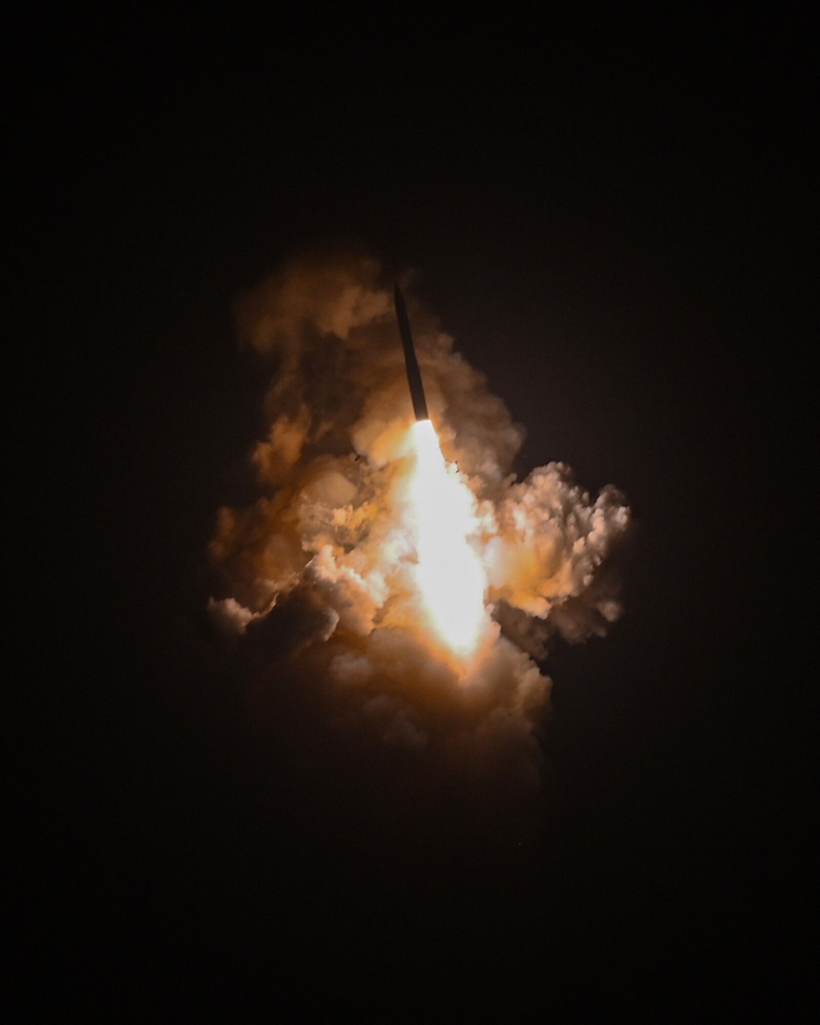 a missile in the dark night sky, white ethereal clouds surrounding it