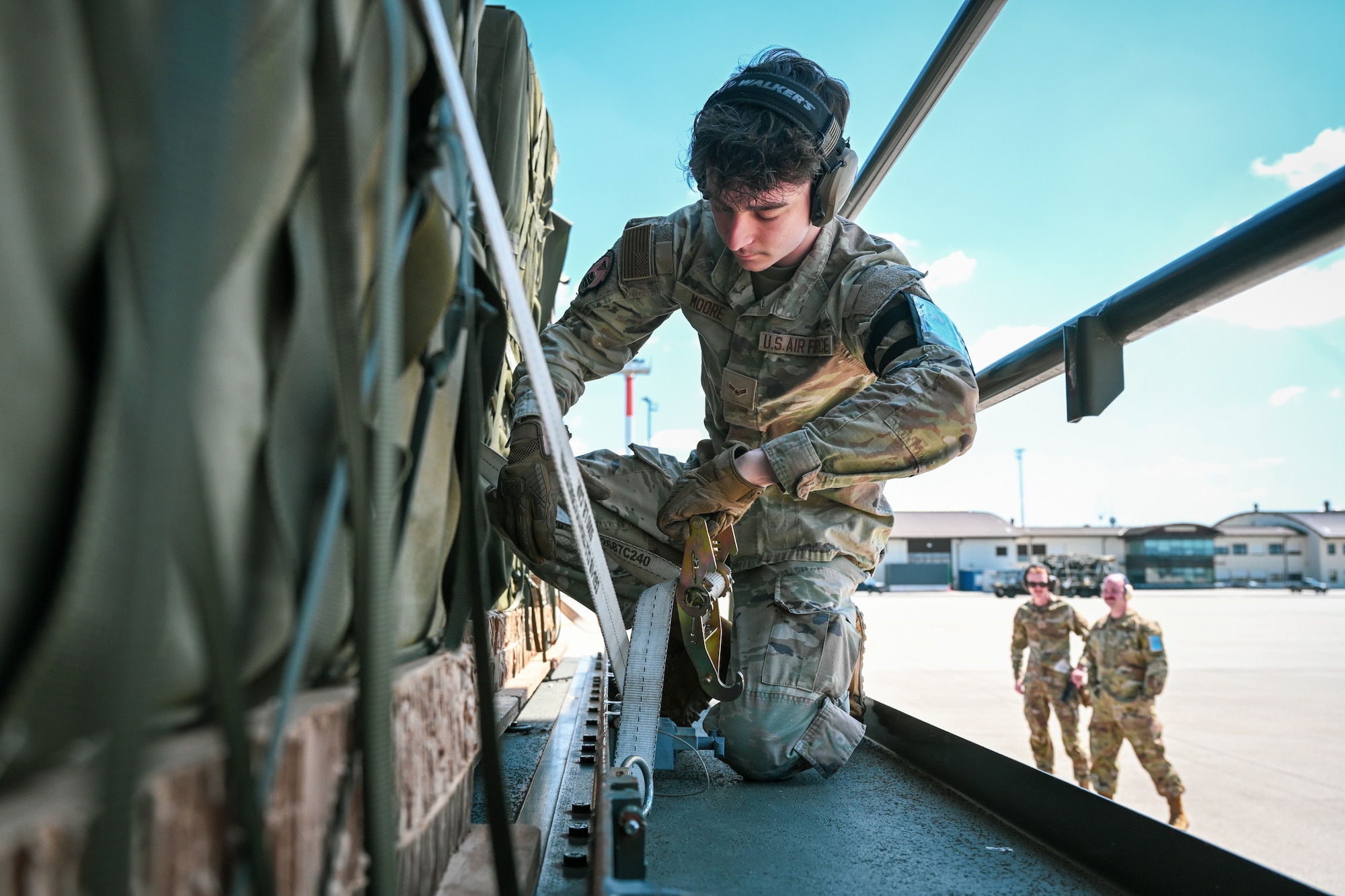 U.S. Air Force Airman 1st Class Jason Moore, a 726th Air Mobility Squadron air freight technician, straps down a pallet on a 25k loader during Swift Response 25 at Spangdahlem Air Base, Germany, May 15, 2025.