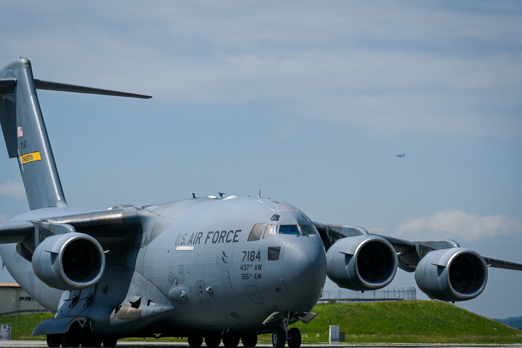 A C-17 Globemaster III taxis on the flightline at Spangdahlem Air Base while another C-17 Globemaster III prepares to land during Swift Response 25, May 15, 2025.