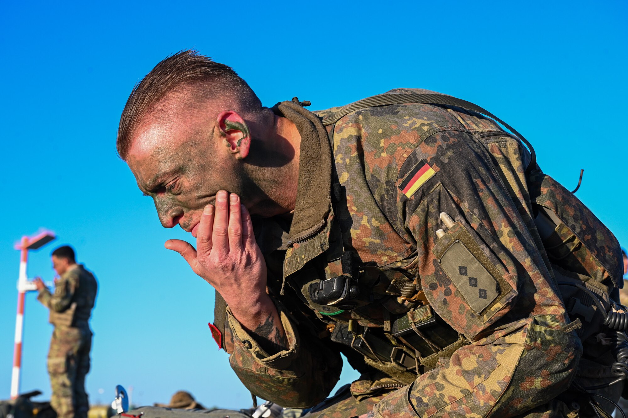 A German Bundeswehr paratrooper applies face paint prior to boarding a C-17 Globemaster III during Swift Response 25 at Spangdahlem Air Base, Germany, May 16, 2025.