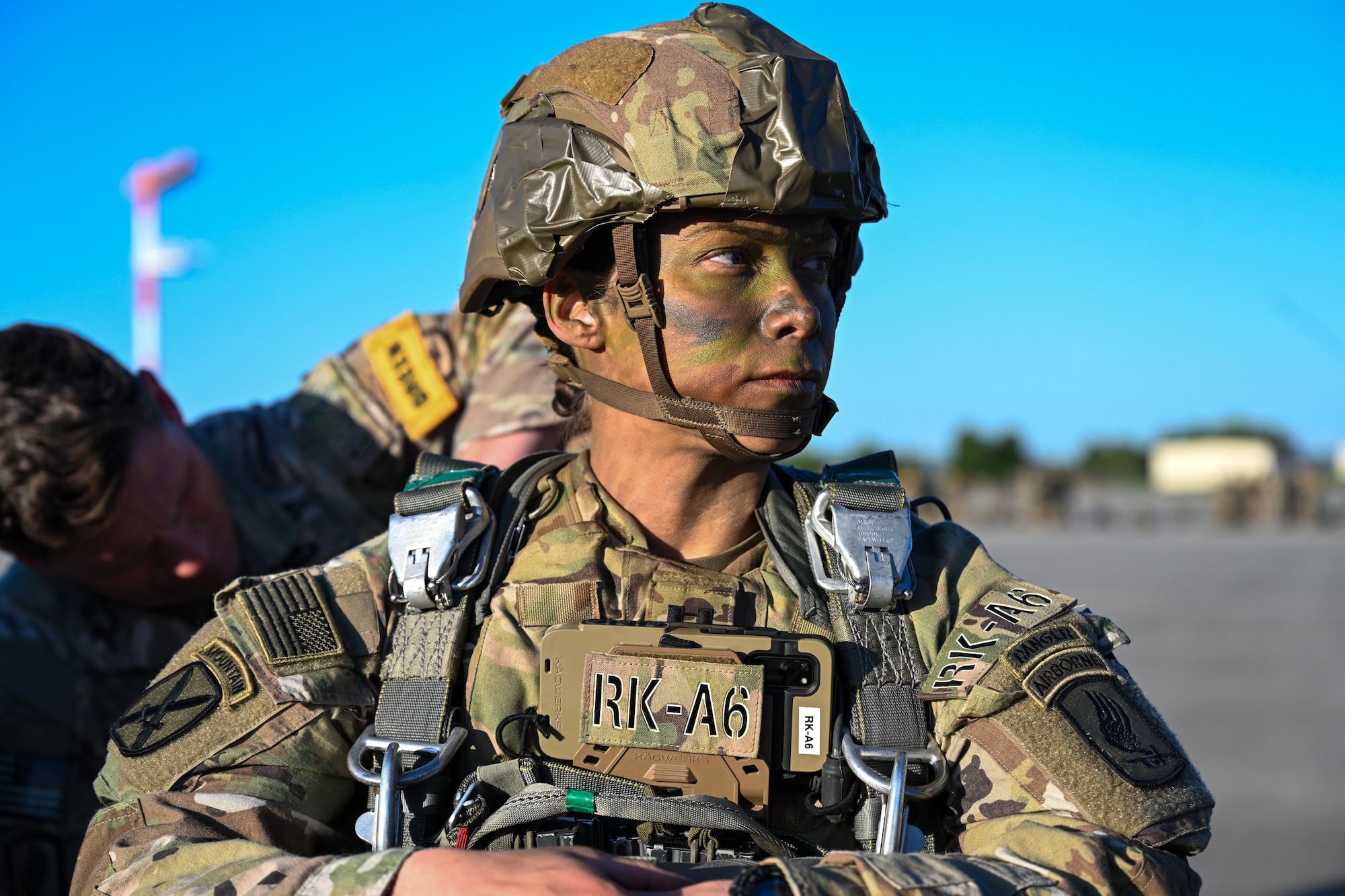 A U.S. Army paratrooper from the 173rd Airborne Brigade has a battle buddy check her parachute rig before boarding a C-17 Globemaster III during Swift Response 25 on the flightline at Spangdahlem Air Base, Germany, May 16, 2025.