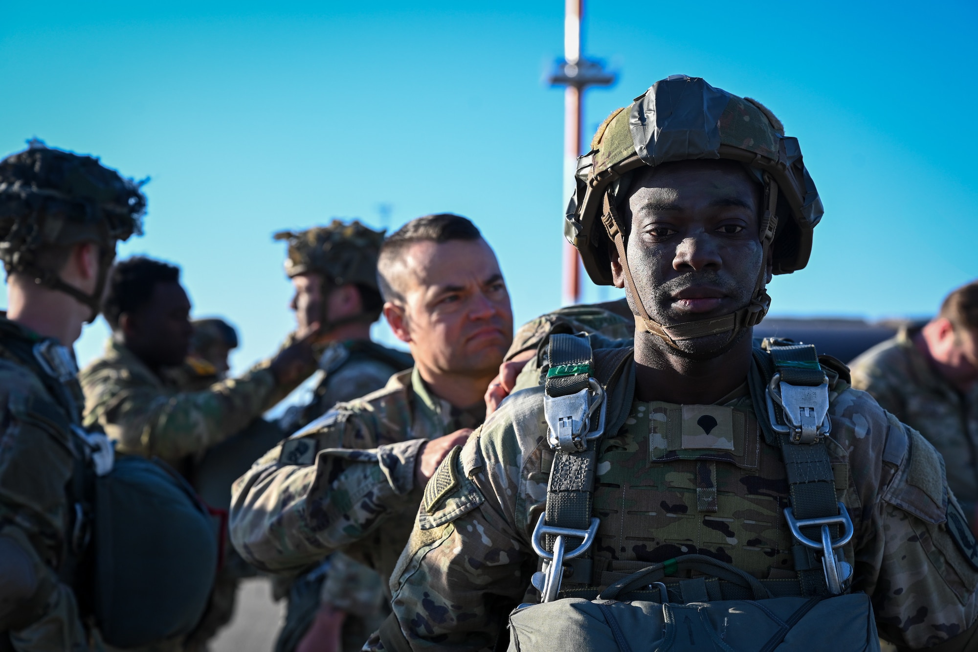 A U.S. Army paratrooper from the 173rd Airborne Brigade has a battle buddy check his parachute rig before boarding a C-17 Globemaster III during Swift Response 25 on the flightline at Spangdahlem Air Base, Germany, May 16, 2025.
