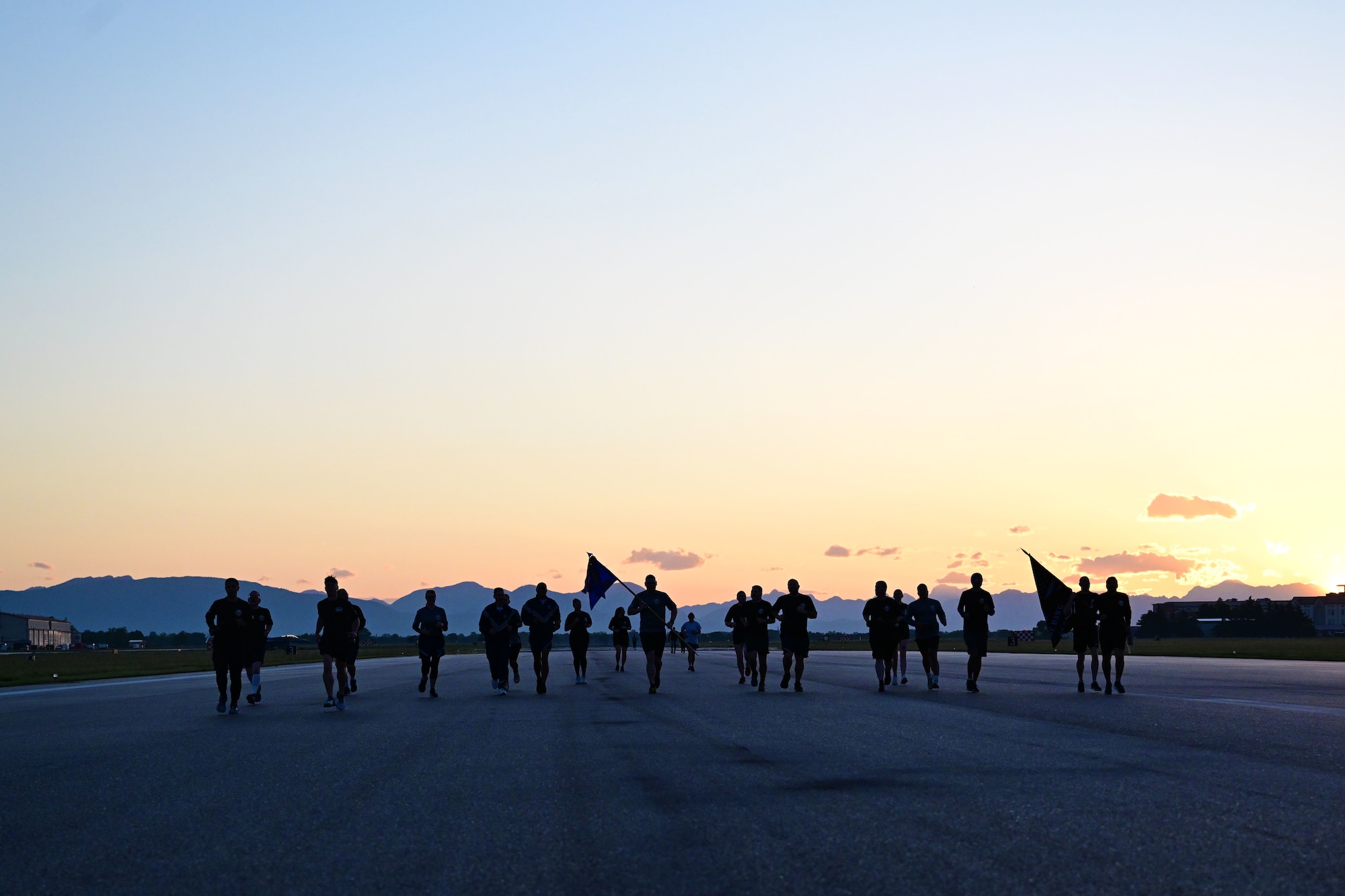 People run down the flightline at sunrise.