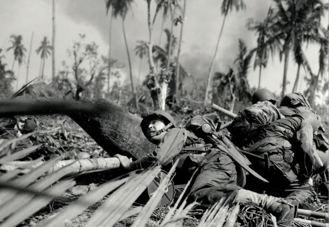 Soldier crouches as enemy fire passes overhead just off one of the beaches on east coast of Leyte Island, Philippines