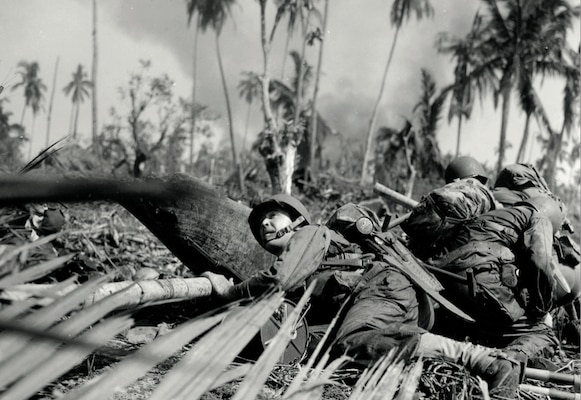 Soldier crouches as enemy fire passes overhead just off one of the beaches on east coast of Leyte Island, Philippines, October 20, 1944 (National Archives and Records Administration/Carl Wienke/U.S. Army Signal Corps)