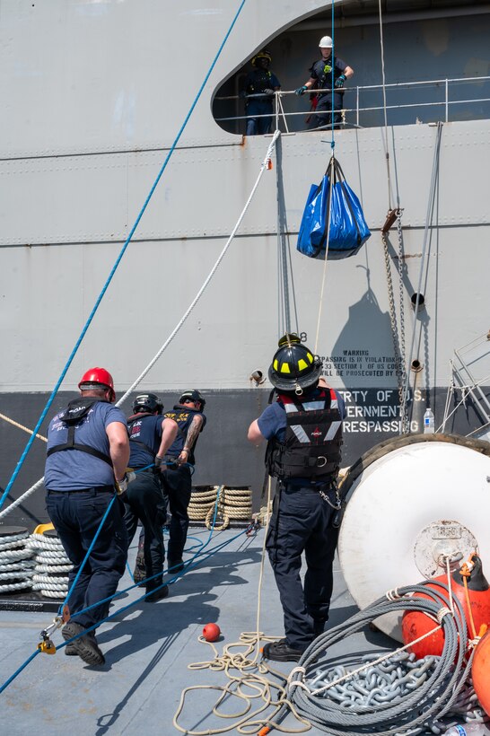 Firefighters lift equipment onto a ship. (U.S. Air Force photo by Airman 1st Class Donnell Ramsey)