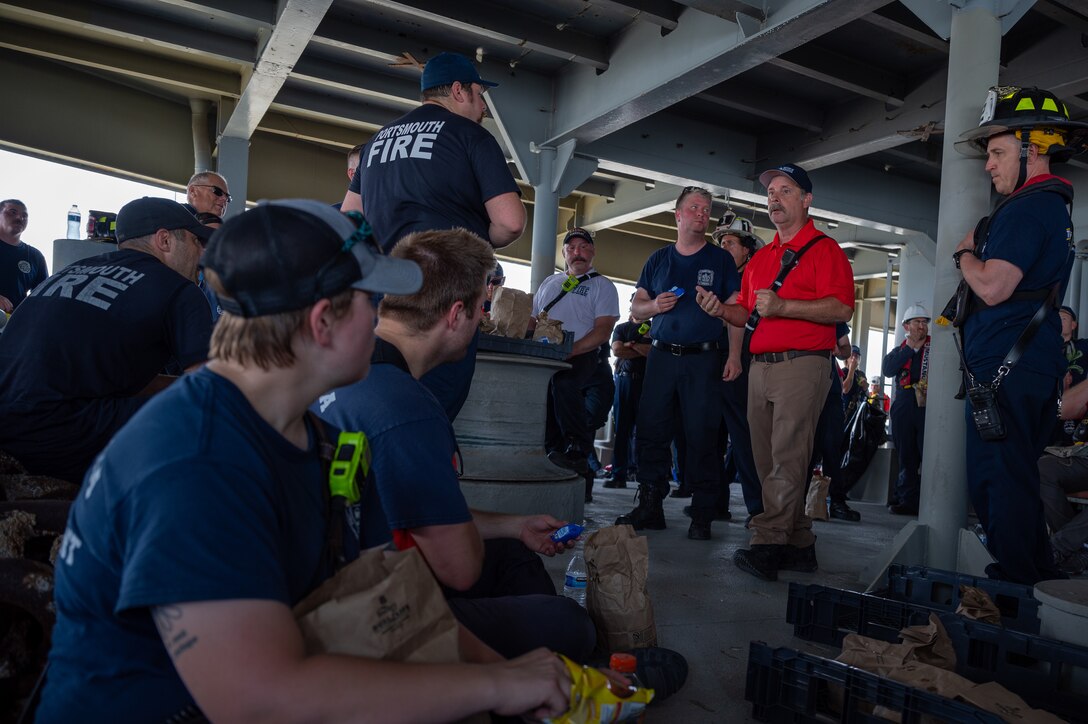 Firefighter speaks to firemen. (U.S. Air Force photo by Airman 1st Class Donnell Ramsey)