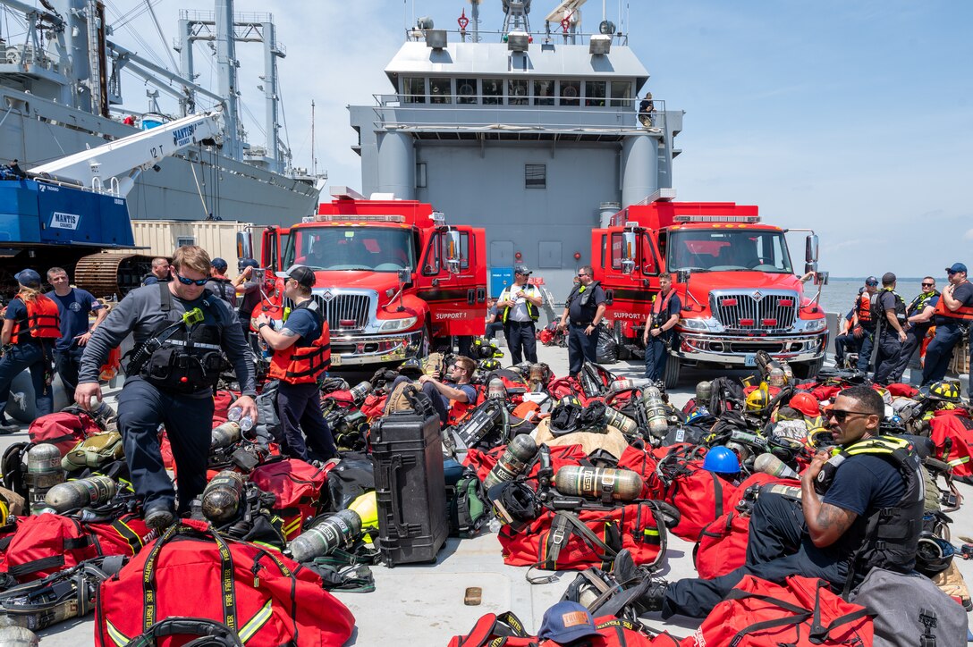 Firefighters gather equipment on a ship. (U.S. Air Force photo by Airman 1st Class Donnell Ramsey)