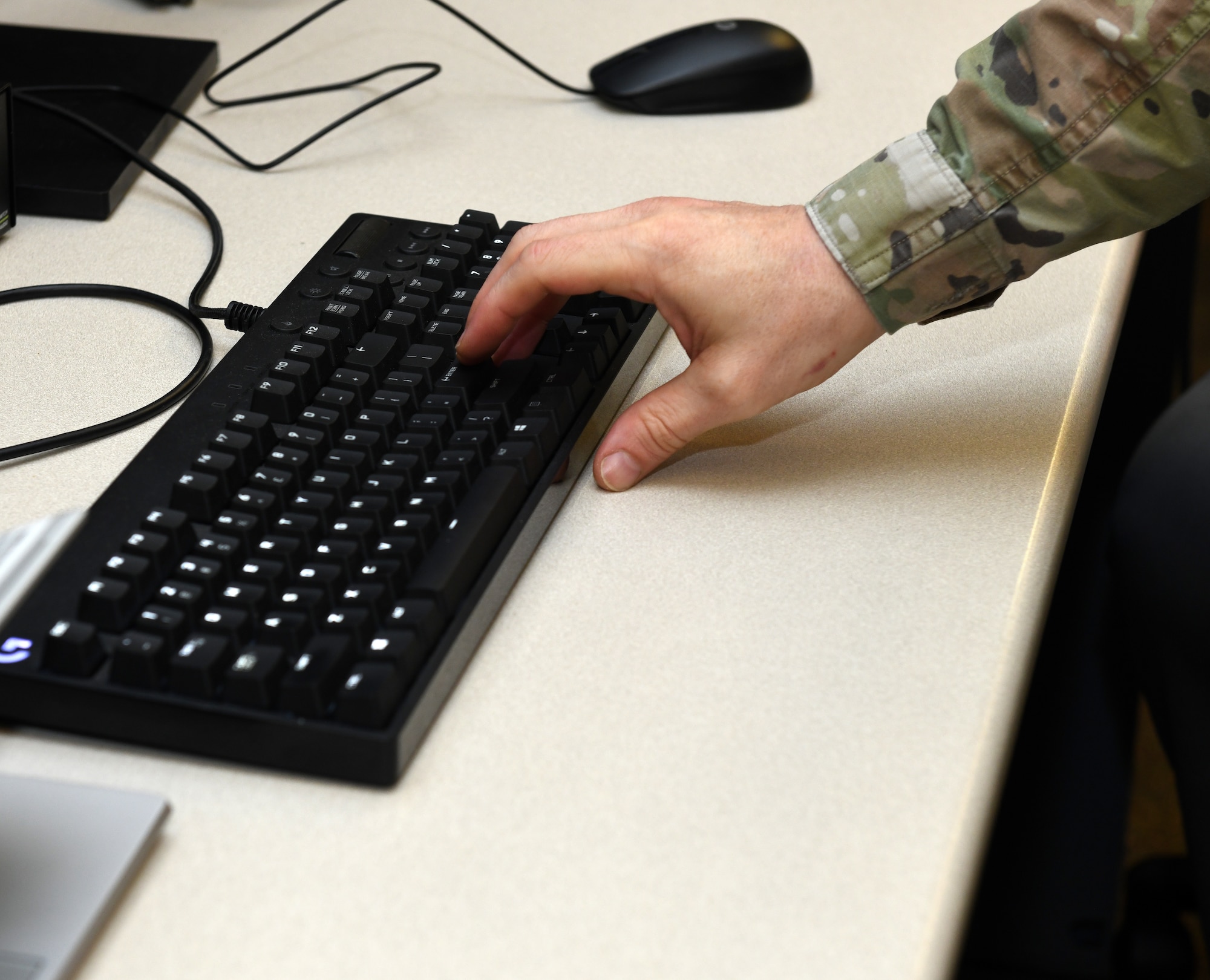 Airman hits the enter key on a keyboard