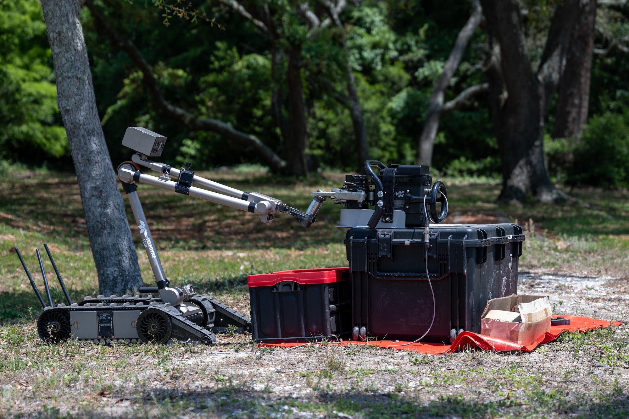 A PackBot 525, a man-transportable multi-mission robot, holds an empty pipe bomb to a Non-Energetic Remote Access Tool during United States Bomb Technician Association Week