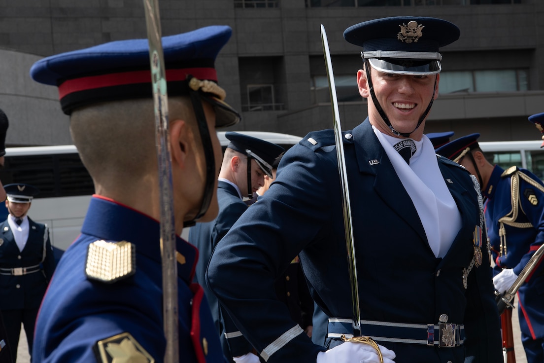 U.S. Air Force 1st Lt. Andrew Paquin, Honor Guard ceremonial operations officer in charge, and a Japan Ground Self-Defense Force soldier assigned to the 302nd Military Police Company stand at attention during a visit to JGSDF Camp Ichigaya, Japan, April 22, 2025. As part of the exchange, the Drill Team performed their routine and observed the 302nd MP Company’s precision drill demonstration, fostering mutual engagement and camaraderie. (U.S. Air Force photo by Yasuo Osakabe)