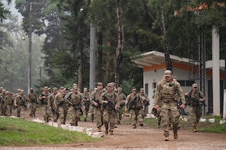 U.S. service members march along a road