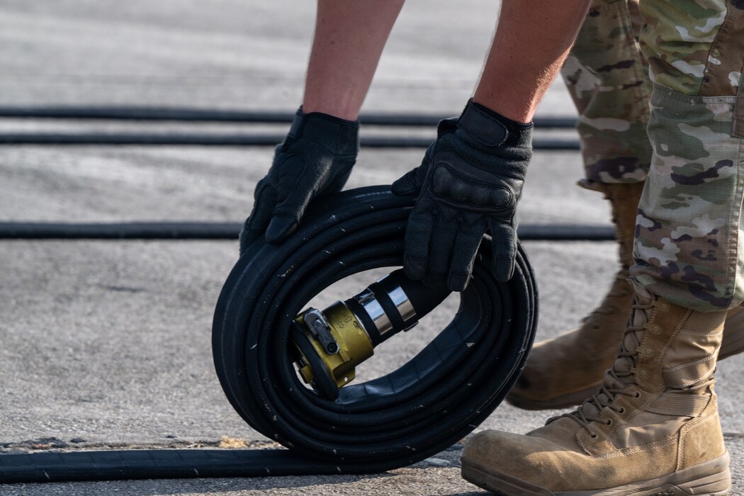 A U.S. Air Force Airman assigned to the 23rd Logistics Readiness Squadron fuels section rolls the fuel hose while trying out for the Forward Area Refueling Point team at Moody Air Force Base, Georgia, May 9, 2025. The purpose of rolling the hose is to ensure no fuel is left within, making it easier to move the hose back to the truck. (U.S. Air Force photo by Airman 1st Class Iain Stanley)