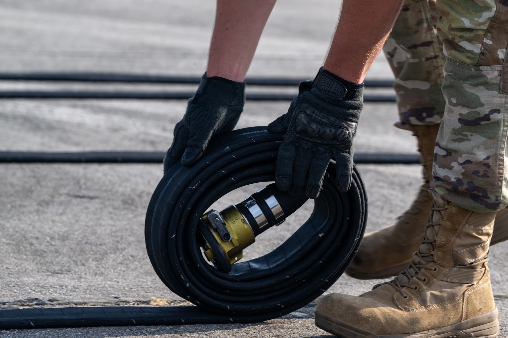 A U.S. Air Force Airman assigned to the 23rd Logistics Readiness Squadron fuels section rolls the fuel hose while trying out for the Forward Area Refueling Point team at Moody Air Force Base, Georgia, May 9, 2025. The purpose of rolling the hose is to ensure no fuel is left within, making it easier to move the hose back to the truck. (U.S. Air Force photo by Airman 1st Class Iain Stanley)
