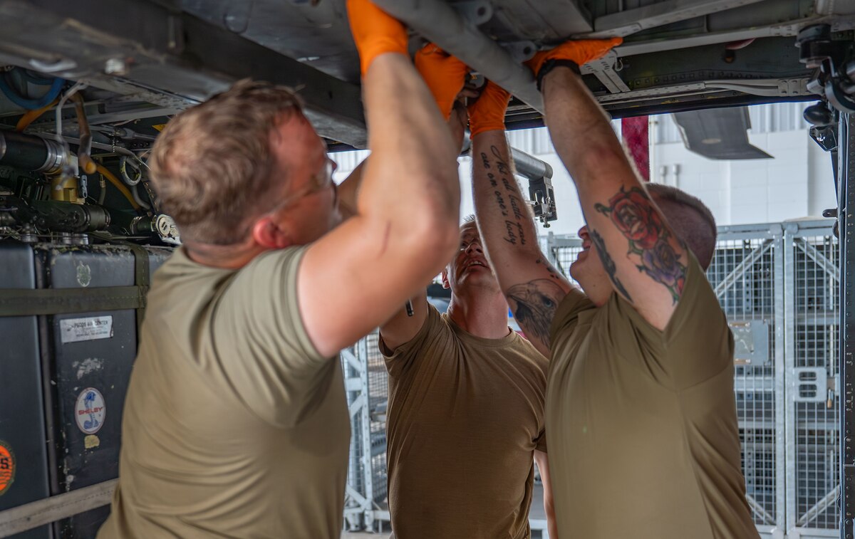 Crew Chiefs from the 920th Maintenance Squadron reinstall the Fast Rope Insertion/Extraction System bar