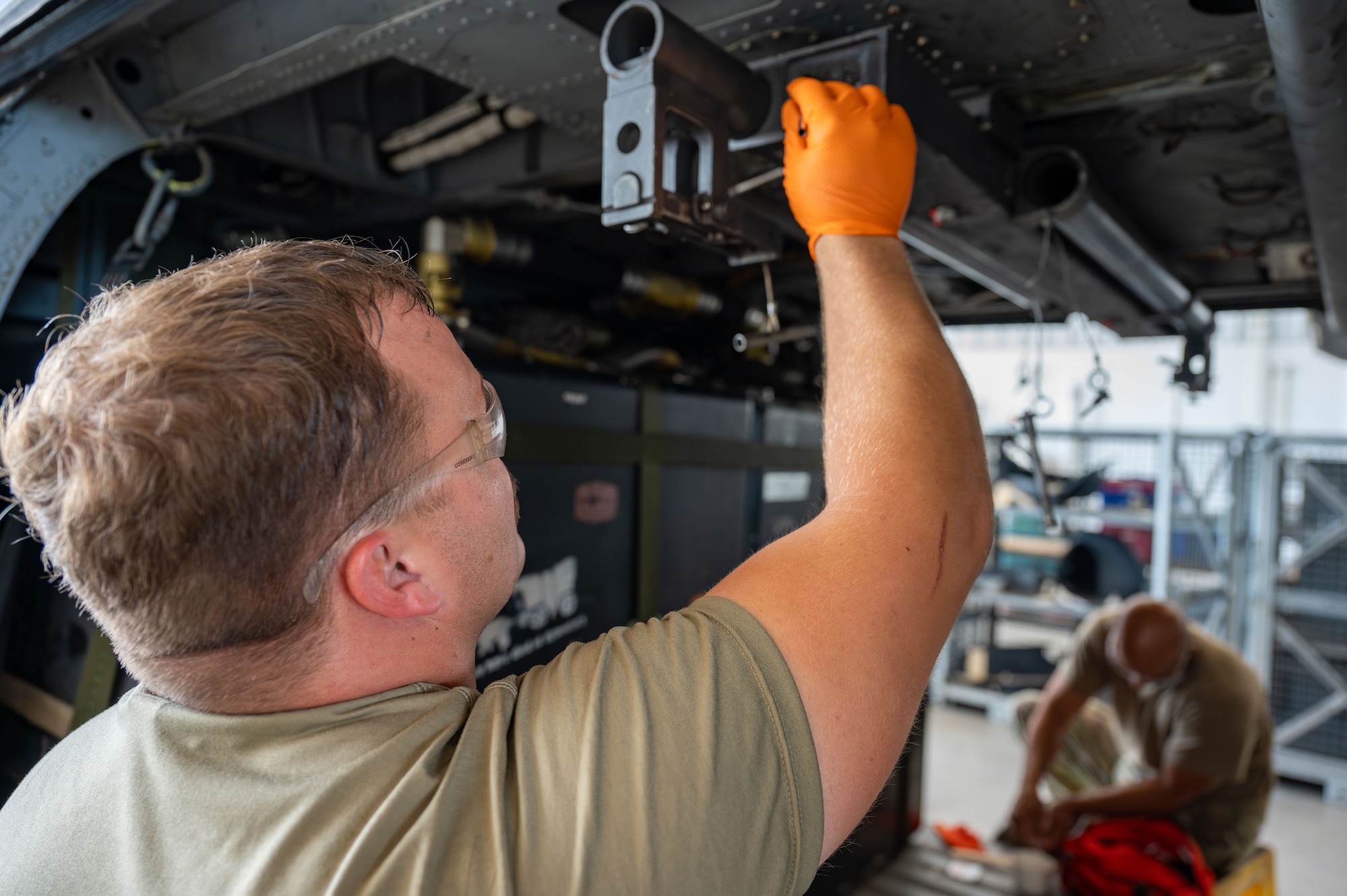 Staff Sgt. Campbell Lawton applies sealant to the Fast Rope Insertion/Extraction System bar