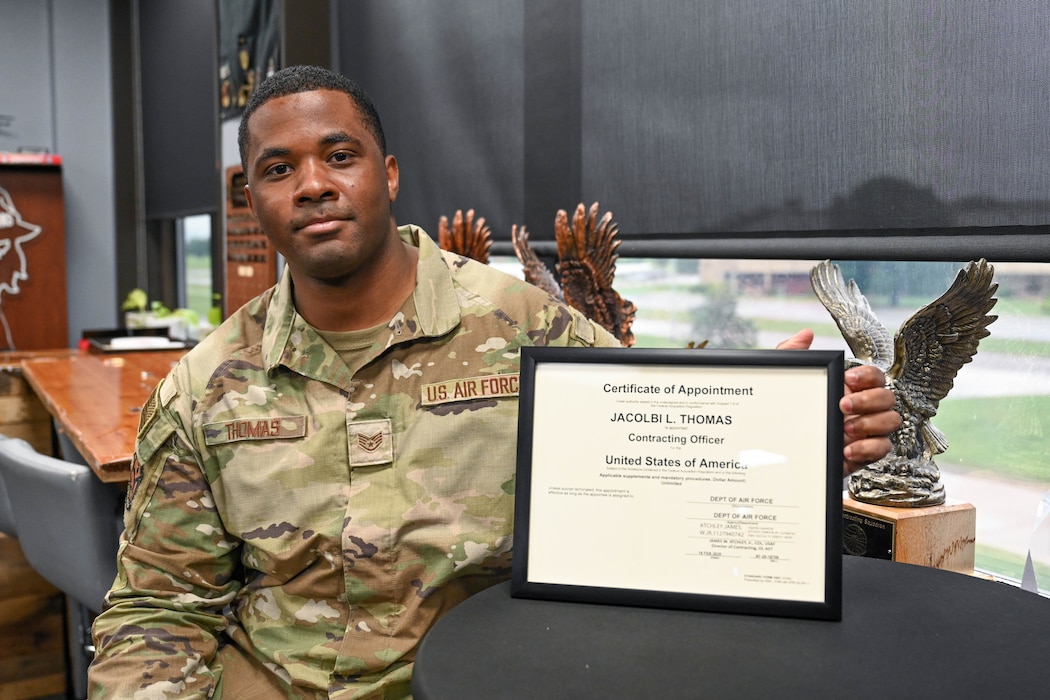 U.S. Air Force Staff Sgt. Jacolbi Thomas, 97th Contracting Flight infrastructure flight chief, poses with his unlimited warrant certificate at Altus Air Force Base, Oklahoma, May 6, 2025. Thomas is now one of a few enlisted Airmen in the Air Force to hold an unlimited contracting warrant. (U.S. Air Force photo by Airman 1st Class Lauren Torres)