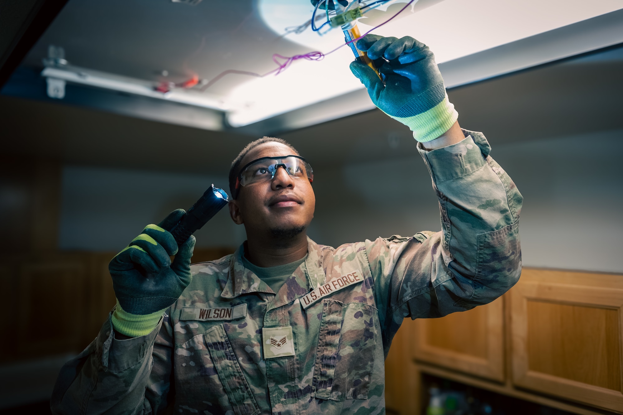 Man holding a flashlight checks on a light
