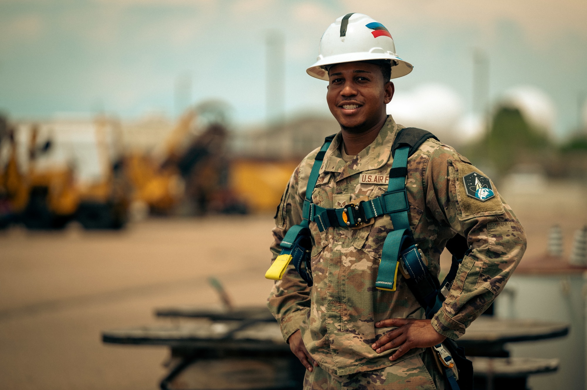 Man poses while wearing electrician gear