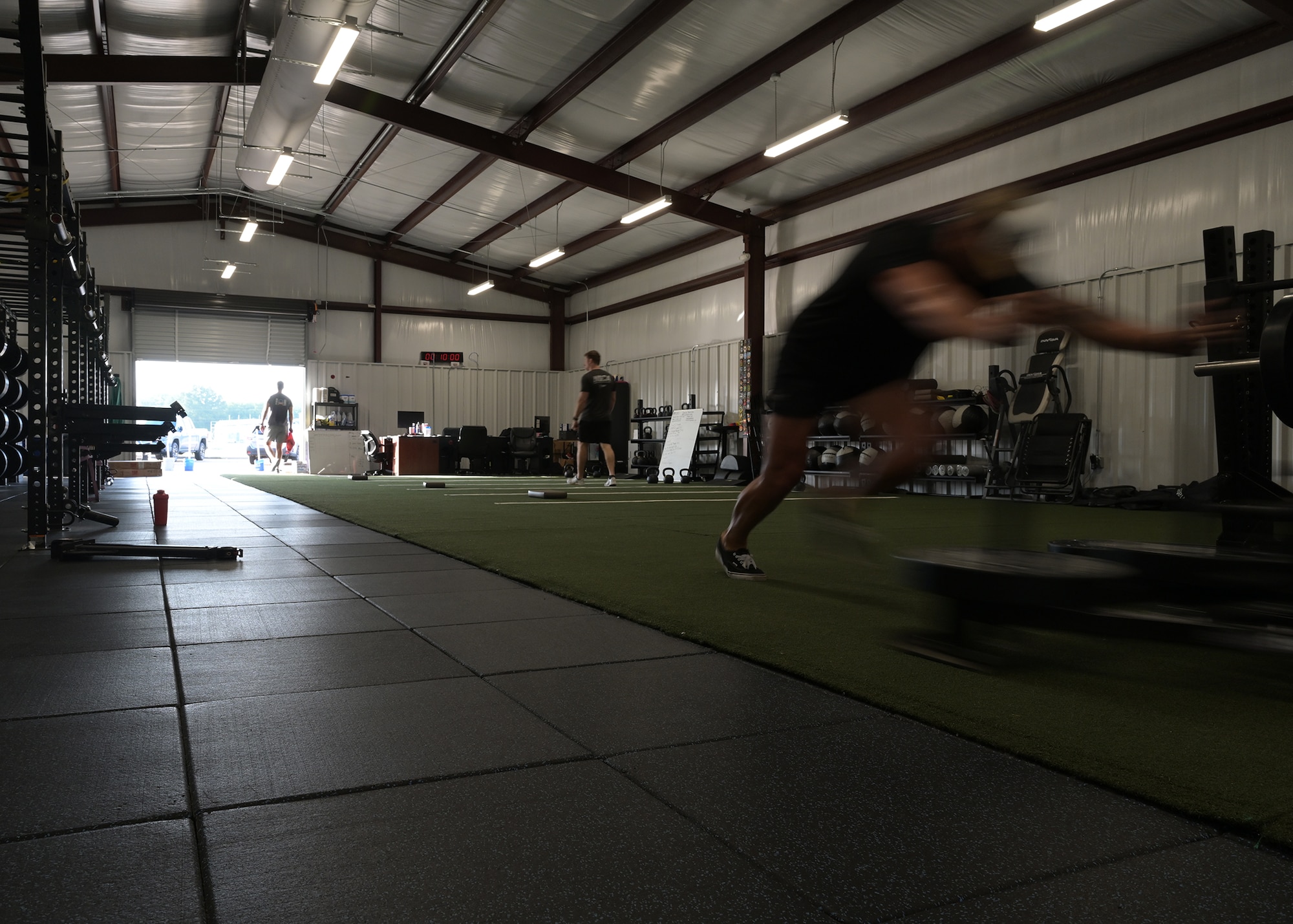 An Airmen pushes a weighted cart in the Comprehensive Readiness for Aircrew Flying Training gym