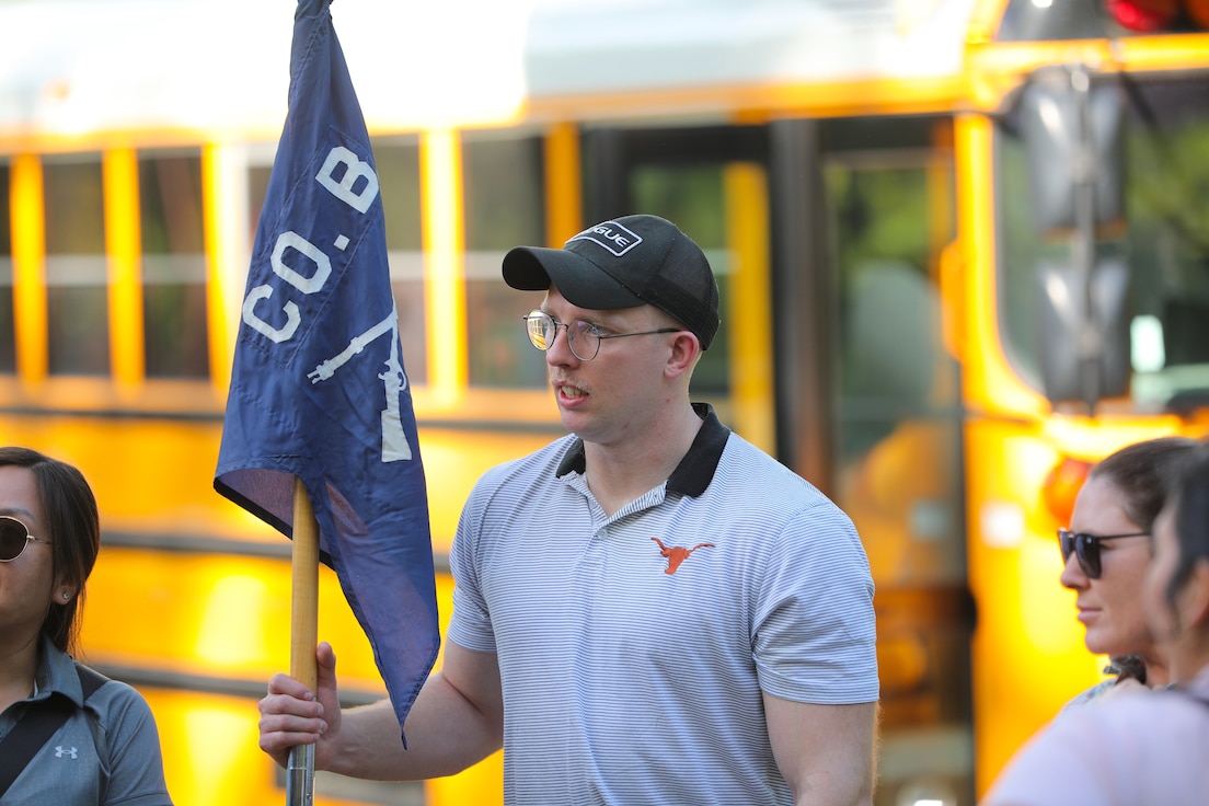 Officer Candidate Parker Meads holds the company guidon as cadre and classmates gather to begin the day’s staff ride activities.