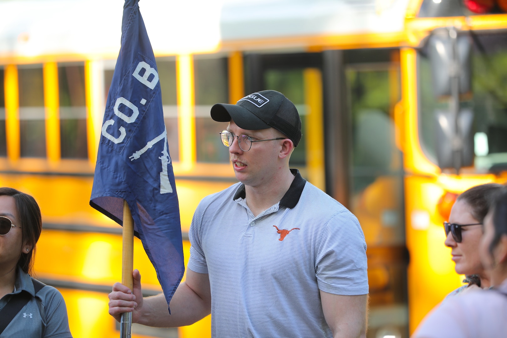 Officer Candidate Parker Meads holds the company guidon as cadre and classmates gather to begin the day’s staff ride activities.