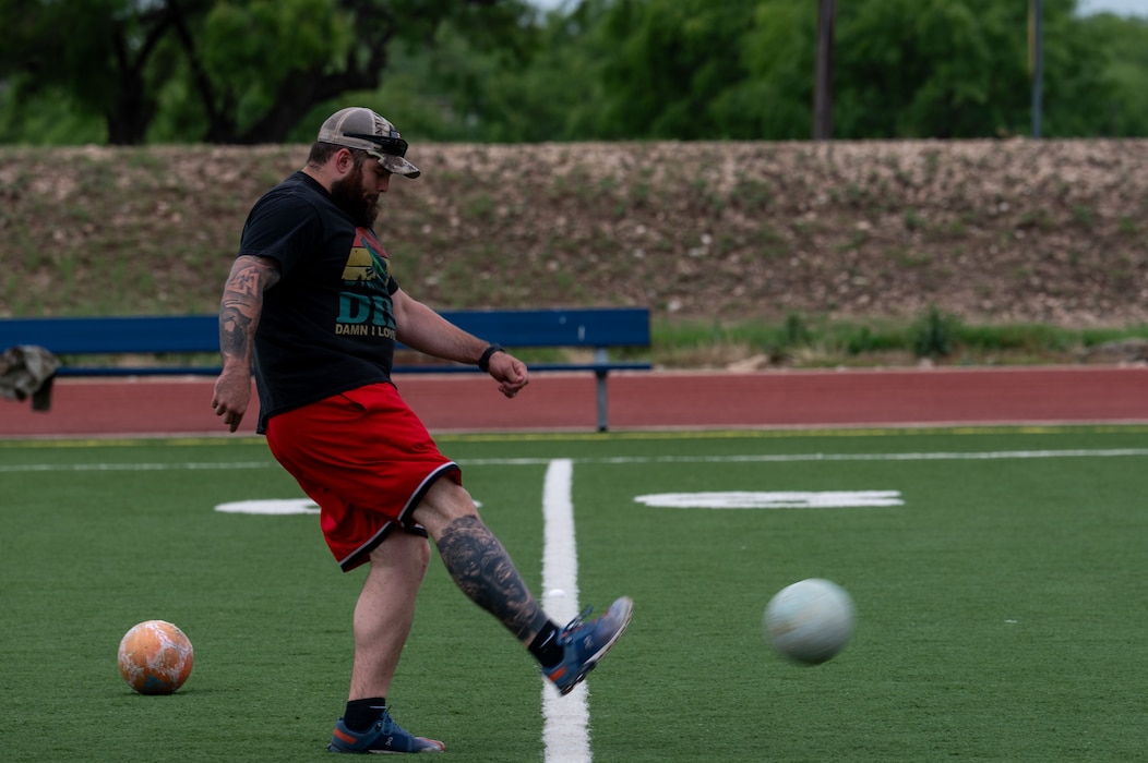 A Defender Challenge participant kicks a soccer ball as part of the physical fitness challenges included in the Defender Challenge at the Mathis Fitness Center track, Goodfellow Air Force Base, Texas, May 14, 2025. The events organized by the 17th Security Forces Squadron throughout the week aimed to not only commemorate the fallen but also foster camaraderie and teamwork among service members. (U.S. Air Force photo by Airman 1st Class James Salellas)