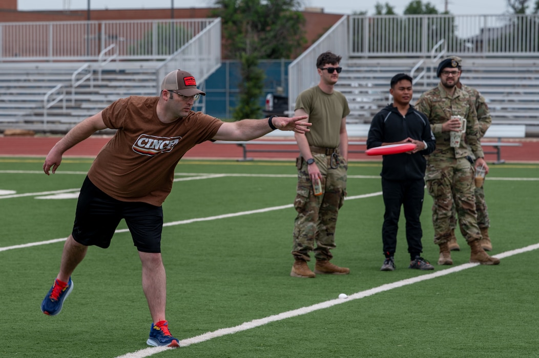 U.S. Air Force Staff Sgt. Kevin Campbell, 17th Security Forces Squadron Combat Arms Training and Maintenance instructor, throws a frisbee as part of the Defender Challenge at the Mathis Fitness Center track, Goodfellow Air Force Base, Texas, May 14, 2025. The event featured physical fitness challenges promoting teamwork and friendly competition among participants from the base and local law enforcement. (U.S. Air Force photo by Airman 1st Class James Salellas)