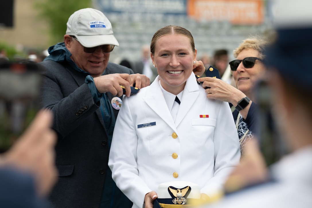 U.S. Coast Guard Academy (USCGA) Ensign. Kira Howard’s(middle)family members put on her shoulder boards after commencement ceremony on Cadet Memorial Field during the 144th Commencement Exercises at USCGA, New London, Connecticut, May 21, 2025. Department of Homeland Security Secretary Kristi Noem shared the details of Force Design 2028, which includes plans to purchase new aircraft, grow the workforce by 15,000 people, fix aging facilities, and begin a once-in-a-generation transformation of the 234-year old maritime service.  (U.S. Coast Guard photo by Petty Officer Second Class Janessa Warschkow.)
