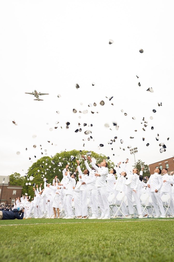 U.S. Coast Guard Academy (USCGA) Class of 2025 throws their combination covers into the air during a flyover during their commencement ceremony on Cadet Memorial Field during the 144th Commencement Exercises at USCGA, New London, Connecticut, May 21, 2025. USCGA commissioned approximately 260 new officers. (U.S. Coast Guard photo courtesy photo.)