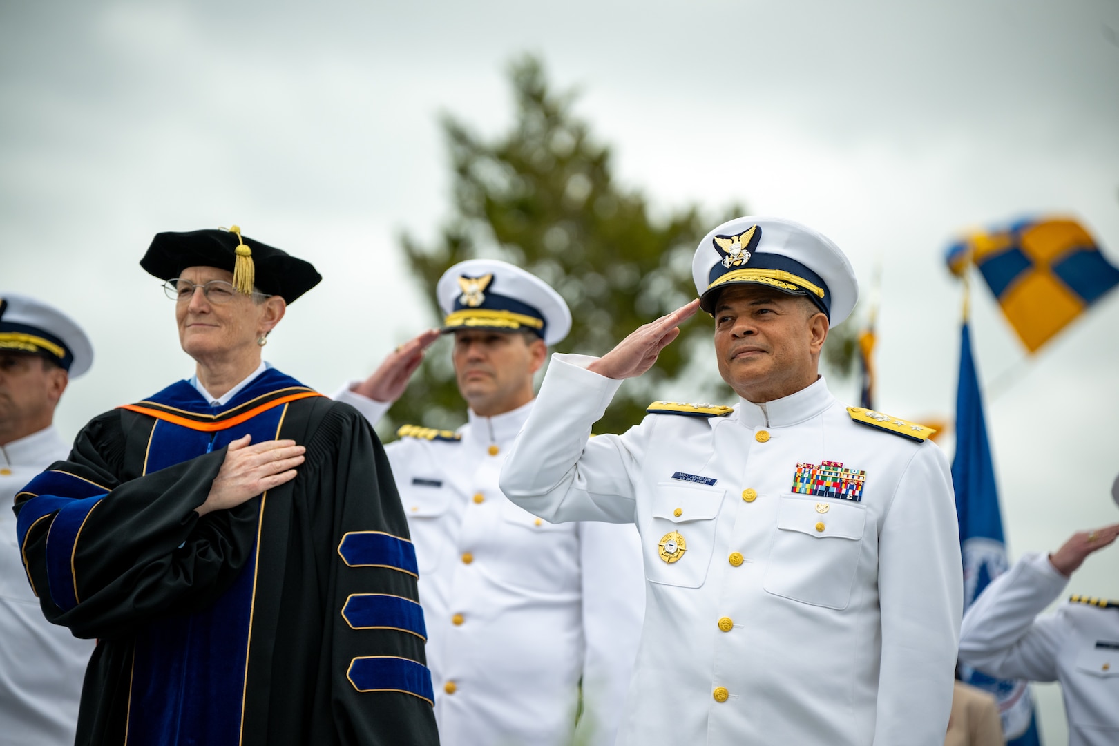 U.S. Coast Guard Academy (USCGA) Superintendent Rear Adm. Mike Johnston (front right) and Provost Amy Donahue render honors during the 144th Commencement Exercises at USCGA, New London, Connecticut, May 21, 2025. Donahue recalled fond memories from her time with the Class of 2025 and wished them well on the new chapters of their careers. (U.S. Coast Guard photo by Petty Officer Third Class Leo Avila.)