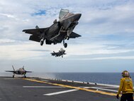 Two F-35B Lightning II fighter aircrafts from Marine Fighter Attack Squadron (VMFA) 242, prepare to land on the flight deck the forward-deployed amphibious assault ship USS America (LHA 6) while conducting flight operations in the East China Sea, May 20.