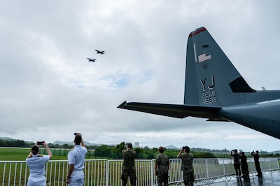 U.S. Navy and U.S. Air Force personnel watch as two F/A-18E Super Hornets from Carrier Air Wing (CVW) 17 perform a fly-over at the Langkawi International Maritime and Aerospace Exhibition 2025 in Langkawi, Malaysia, May 20, 2025. Carrier Air Wing (CVW) 17 is in the U.S. 7th Fleet area of operations on a scheduled deployment, demonstrating the U.S. Navy's unwavering commitment to a free and open Indo-Pacific. (U.S. Air Force photo by Senior Airman Alexzandra Gracey)